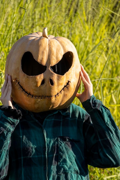 Jonge vrouw met pompoenhoofd na het afsnijden en er een gezicht op te zetten halloween