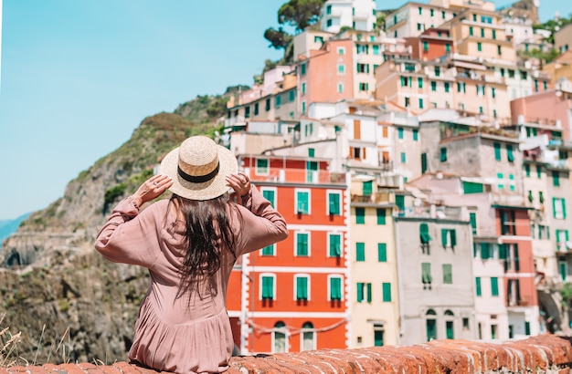 Jonge vrouw met prachtig uitzicht op het oude dorp Riomaggiore, Cinque Terre, Ligurië