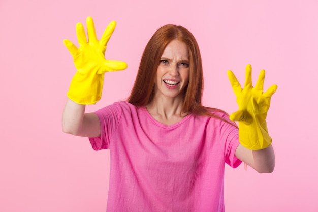 Jonge vrouw met rood haar in gele rubberhandschoenen