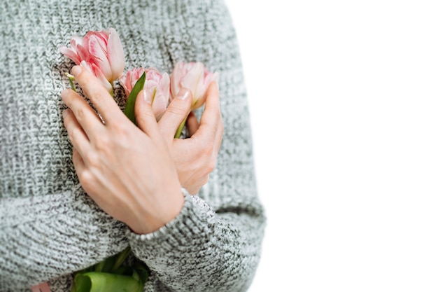 Jonge vrouw met roze tulpen op een witte achtergrond. Vervagen portret, close-up, kopieer ruimte.