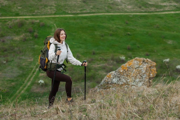 Jonge vrouw met rugzak wandelen in de bergen Wandelconcept Trekking kliffen Reizen reiziger