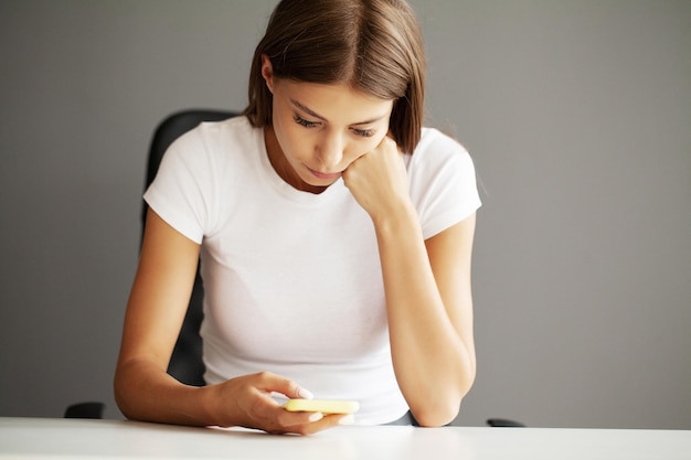 Jonge vrouw met smartphone bericht te typen chatten met vrienden in sociale netwerken