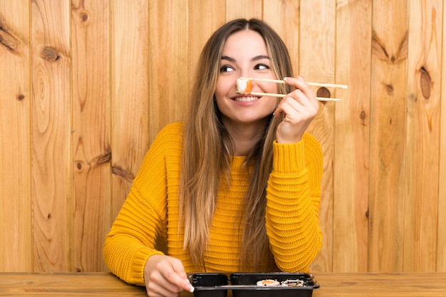 Jonge vrouw met sushi over hout