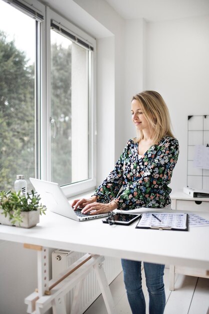 Foto jonge vrouw met telefoon op tafel.