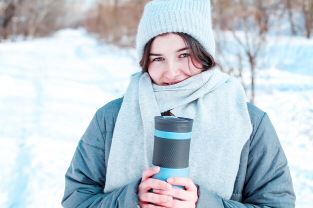 Jonge vrouw met thermoskan GLB