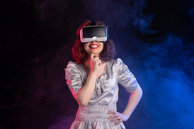 Jonge vrouw met virtual reality headset op donkerblauw oppervlak