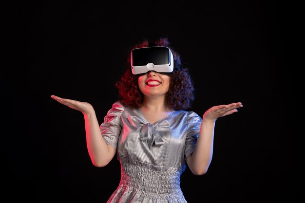 Jonge vrouw met virtual reality headset op donkere ondergrond