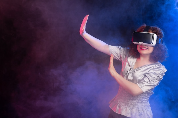 Jonge vrouw met virtual reality headset op donkere ondergrond