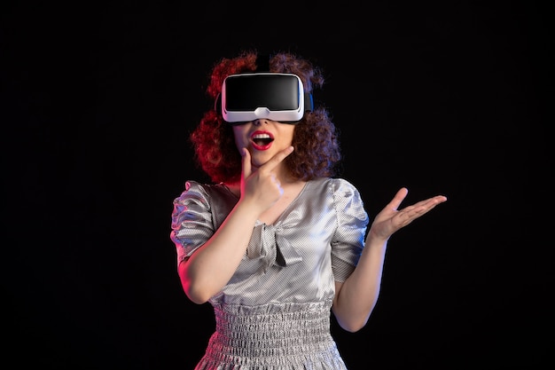 Jonge vrouw met virtual reality headset op donkere ondergrond