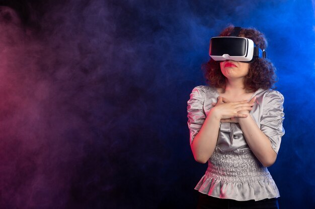 Jonge vrouw met virtual reality headset op donkere rokerige oppervlak