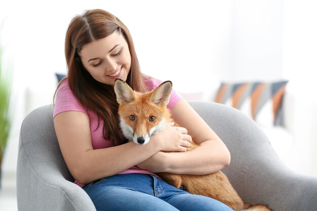 Jonge vrouw met vos binnenshuis