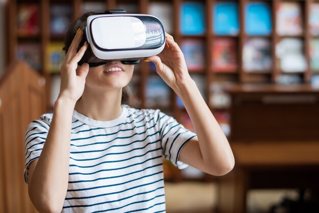 Jonge vrouw met vr-bril virtueel scherm kijken tijdens deelname aan de conferentie of het voorbereiden van rapport