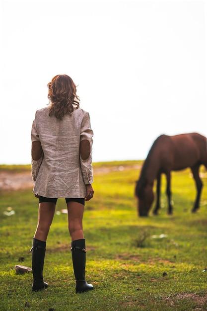 Foto jonge vrouw met wild paard buitenshuis