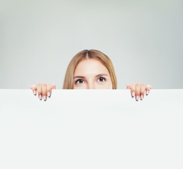 Foto jonge vrouw met witte lege papieren bord banner achtergrond met kopieerruimte