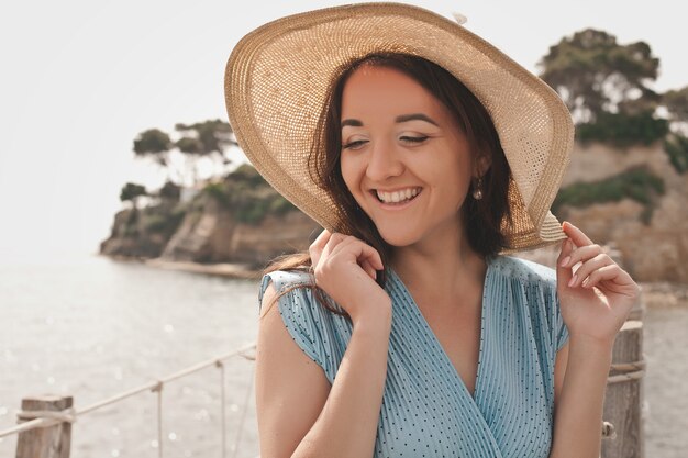 Jonge vrouw met zomerhoed die zich voordeed op de brug