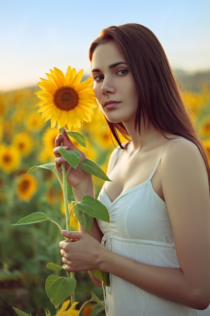 Jonge vrouw met zonnebloem op zomer veld