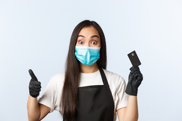 Jonge vrouw met zwarte schort die medisch masker draagt