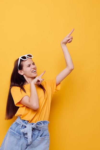 Jonge vrouw mode in gele tshirt denim shorts gele achtergrond