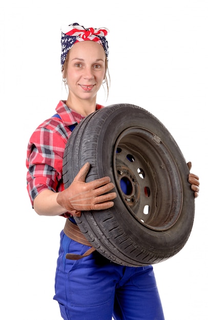 Jonge vrouw monteur met een auto wiel