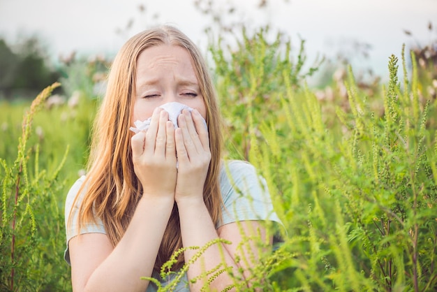 Jonge vrouw niest vanwege allergie voor ambrosia