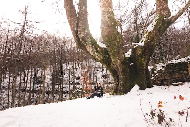 Jonge vrouw onder een enorme beuk in het bos van Baskenland.