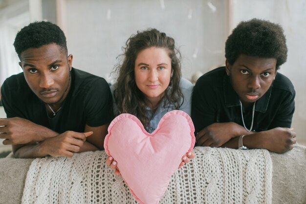 Jonge vrouw onder jonge mannen op het bed