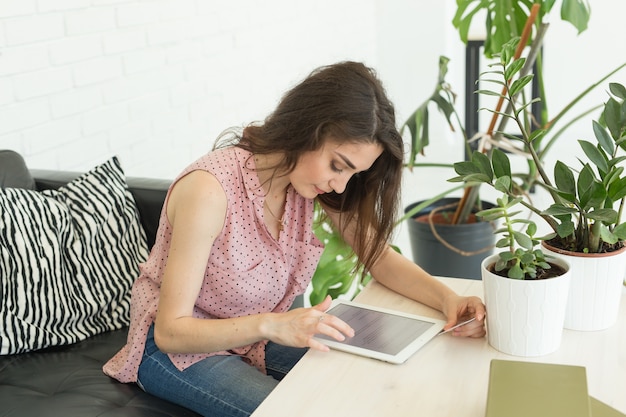 Jonge vrouw online winkelen met behulp van tablet en creditcard in de woonkamer