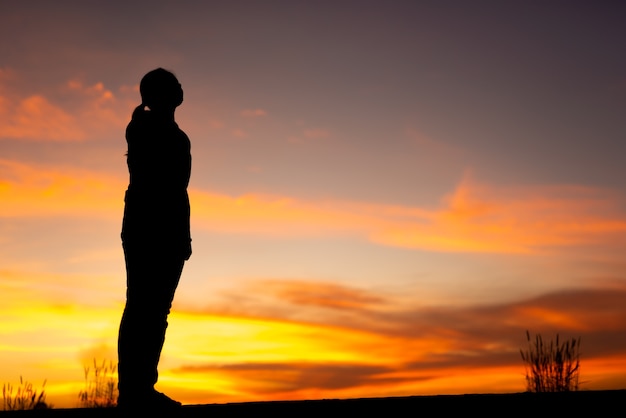 Jonge vrouw ontspannen in de winter zonsondergang hemel buiten.