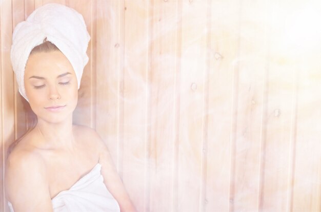 Jonge vrouw ontspannen in een sauna