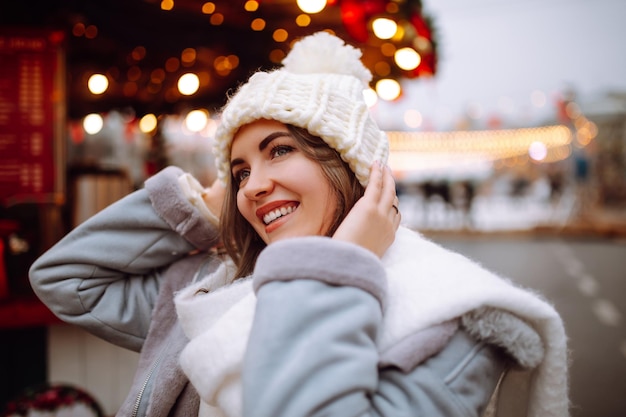 Jonge vrouw ontspannen koffie drinken in feestelijke kerstmarkt Wintervakantie Lichten rond