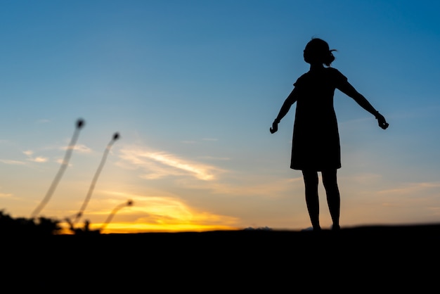 Jonge vrouw ontspannen met zonsondergang