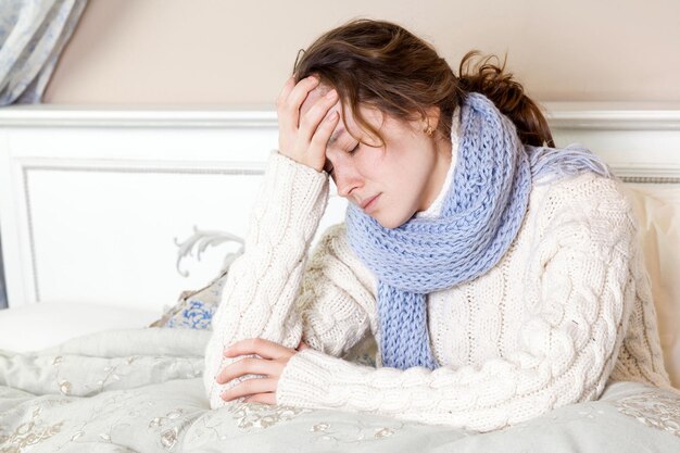 Foto jonge vrouw ontspant zich thuis op bed.