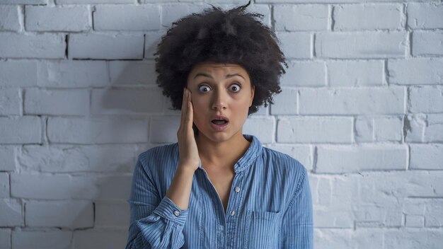 Jonge vrouw ontvangt schokkend slecht nieuws staart naar de camera geschokt aanraken gezicht en vallen kaak stan