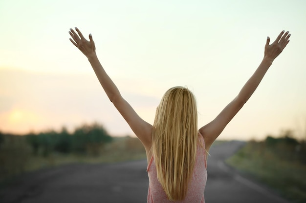 Foto jonge vrouw op avondrood achtergrond