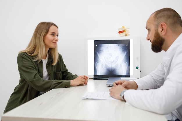 Jonge vrouw op bezoek bij orthopedist in medisch kantoor