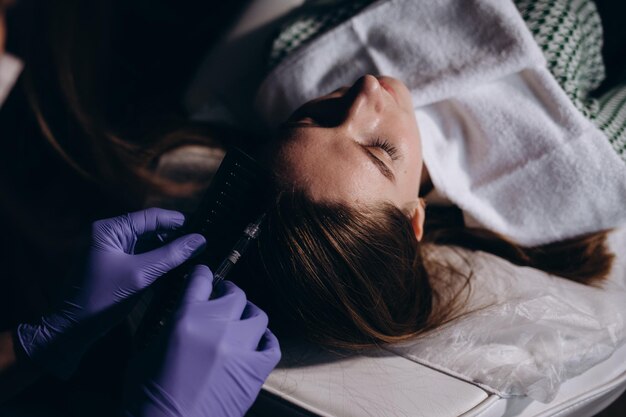 Jonge vrouw op bezoek bij tricholoog in lichte kliniek