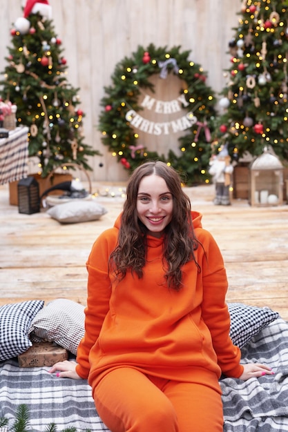 Jonge vrouw op de achtergrond van de kerstboom met geschenken buiten Achtertuin decoratie nieuwjaar