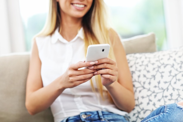 jonge vrouw op de bank met smartphone