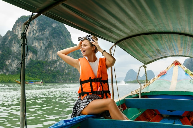 Jonge vrouw op de longtailboot tijdens haar vakanties in Thailand