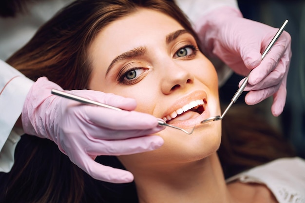 Jonge vrouw op de stoel van de tandarts tijdens een tandheelkundige ingreep Overzicht van preventie van tandcariës