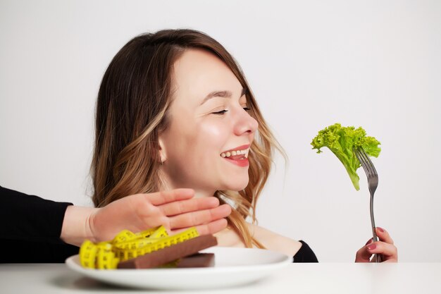 Jonge vrouw op dieet, eet alleen salade en probeert af te vallen