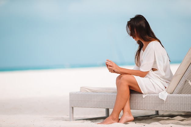 Jonge vrouw op een tropisch strand met hoed