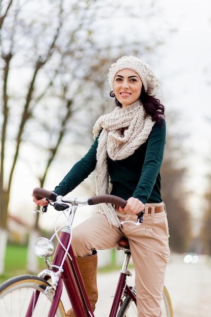 Jonge vrouw op fiets in de winter