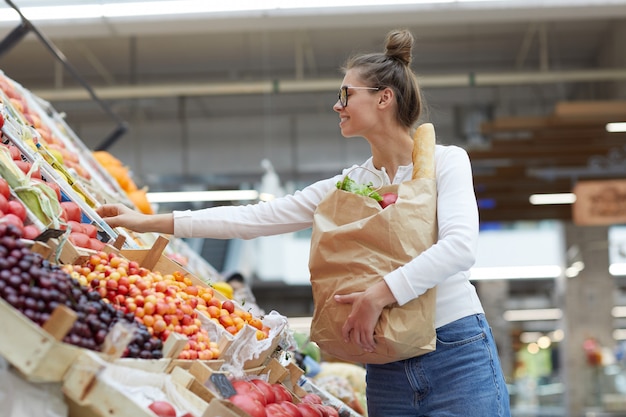 Jonge vrouw op Fruit Stand