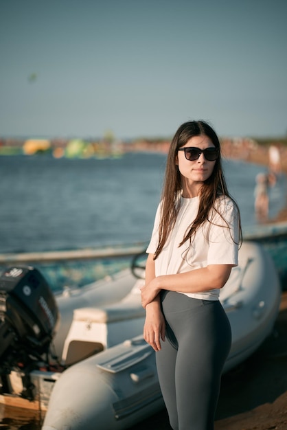 Jonge vrouw op het strand met lang haar Fit mooi meisje draagt wit shirt en grijze legging op het strand