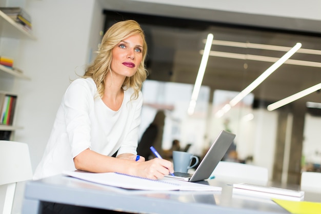 Foto jonge vrouw op kantoor