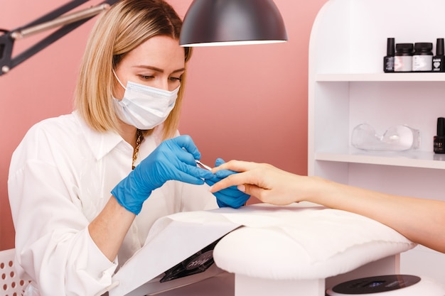 Jonge vrouw op manicurebehandeling in de schoonheidssalon