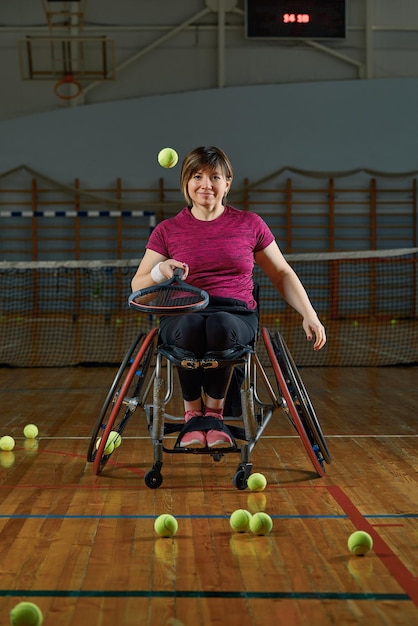 Jonge vrouw op rolstoel tennissen op tennisbaan