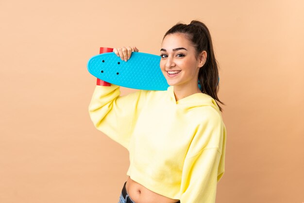 Foto jonge vrouw op roze met een skate