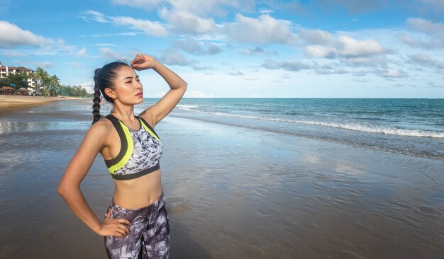 jonge vrouw op sportkleding oefening op het strand